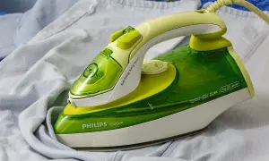 Zielone żelazko Philips EcoCare na jasnych ubraniach. Dowiedz się, jak wyczyścić żelazko, by prasowanie było efektywne.