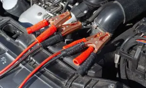 Kable rozruchowe podłączone do akumulatora, bo auto nie odpala. Czerwone i czarne kable z zaciskami.