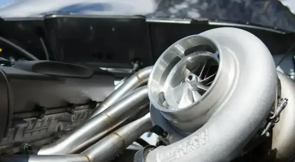 Błyszcząca turbosprężarka p0299 z wirnikiem i kolektorem wydechowym w silniku wyścigowym.