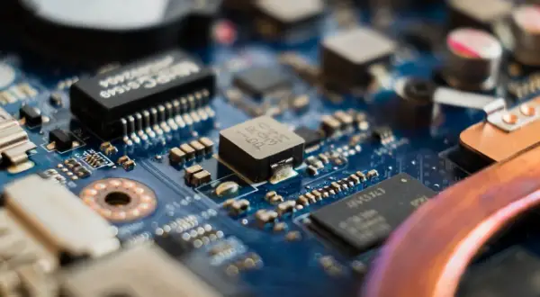Zbliżenie na niebieską płytę główną z widocznymi elementami elektronicznymi, w tym układem **cmos**.
