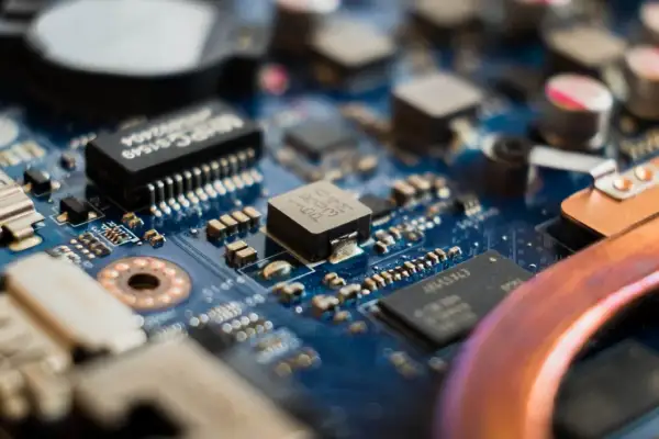 Zbliżenie na niebieską płytę główną z widocznymi elementami elektronicznymi, w tym układem **cmos**.